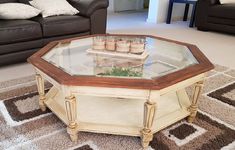 a coffee table with glass top in the middle of a living room