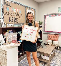 a woman is holding up a sign that says, first grade is our happy place