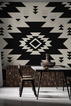 a black and white geometric wallpaper with two chairs at a table in front of it