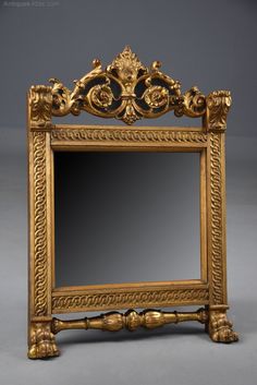 an ornate gold framed mirror sitting on top of a table