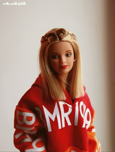 a barbie doll wearing a red sweater with the words mr19 on it's chest