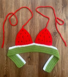 a crocheted watermelon hat and diaper cover laying on the floor