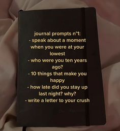 a black book sitting on top of a bed next to a white sheet with the words journal proppsn't speak about a moment when you were at your lowest