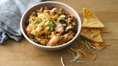 a white bowl filled with chicken and black bean chili on top of a wooden table