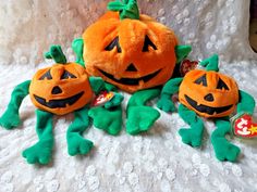 two stuffed pumpkins sitting next to each other on a bed