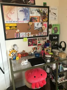 a cluttered desk with various items on it and a large poster above the desk