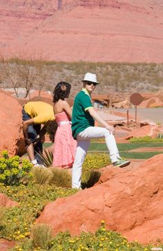 two people standing on rocks in the desert