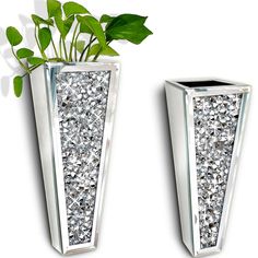 two silver vases with plants in them