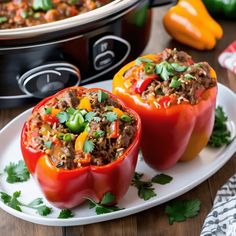 two stuffed bell peppers on a plate next to an instant pot