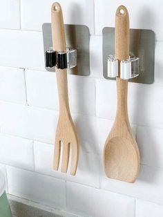 two wooden utensils hanging on the wall