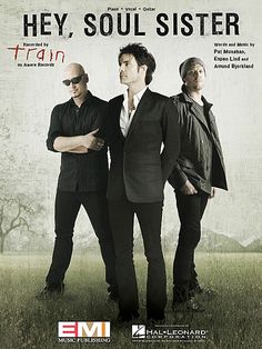 three men standing in front of a grungy background with the words train on it