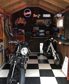 two motorcycles are parked in a garage with checkered floor