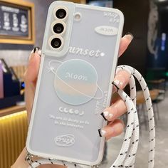 a woman holding up her phone case with the moon on it