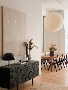 a dining room table with chairs and vases on it