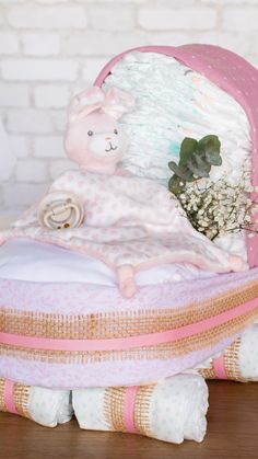 a stuffed animal sitting on top of a bed next to a pillow and flower pot