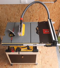 a table sawing machine sitting on top of a piece of plywood