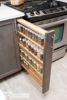 an open cabinet in the middle of a kitchen with spices and condiments on it