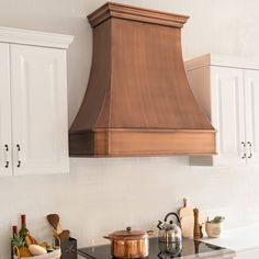 a stove top oven sitting inside of a kitchen next to white cabinets and cupboards