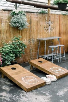 two wooden boards sitting on the ground in front of a wall with potted plants