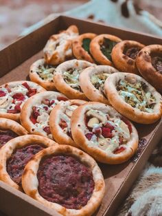 a box filled with lots of different types of pizzas on top of a table