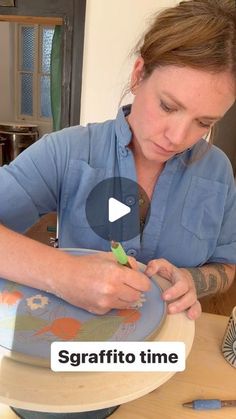 a woman sitting at a table working on something