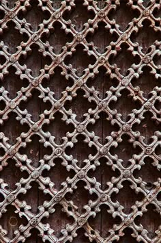 an old wooden door with metal grating on it