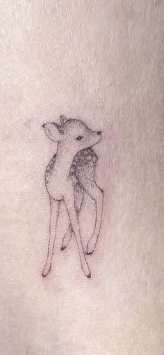 a small tattoo on the back of a woman's stomach with a deer hugging her head