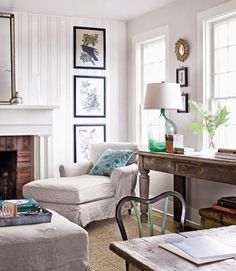 a living room filled with furniture and a fire place in front of a mirror on the wall