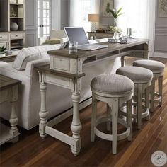 a living room filled with furniture and a laptop computer on top of a wooden table