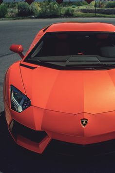 an orange sports car is parked on the street