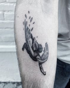 a man with a tattoo on his arm has a bird flying through the air above him