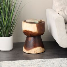 a wooden stool sitting next to a potted plant