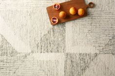 a cutting board topped with oranges on top of a rug