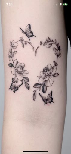 a woman's thigh with flowers and butterflies in the shape of a v on it