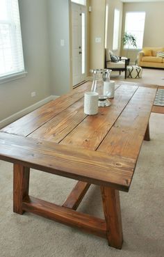 a wooden table with two vases on it in the middle of a living room