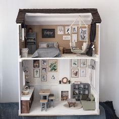 a doll house with furniture and pictures on the walls