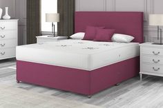 a bed with pink headboard and foot board in a white room next to two nightstands