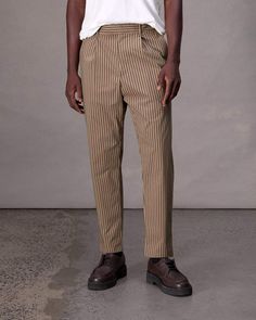 Classic menswear made modern. Our chino is pleated with a slightly tapered silhouette. It's crafted in a striped stretch cotton-blend, perfect for year-round wear. Desert Stripe 31 Tailored Striped Tapered Leg Bottoms, Tailored Tapered Leg Bottoms With Vertical Stripes, Tailored Tapered Leg Pants With Vertical Stripes, Tailored Pants With Vertical Stripes And Tapered Leg, Relaxed Fit Vertical Stripe Workwear Pants, Relaxed Fit Vertical Striped Pants For Workwear, Vertical Stripes Tapered Leg Workwear Bottoms, Tapered Leg Bottoms With Vertical Stripes For Workwear, Men Apparel