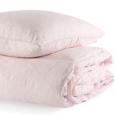 two pink pillows stacked on top of each other with the covers pulled back and folded down