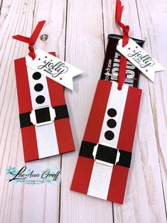 two red and white tags with black dots on them, one has a santa clause