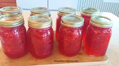 several jars filled with red liquid sitting on top of a table