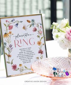 there is a sign that says please the ring next to a vase with flowers in it