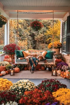 a porch covered in lots of flowers and pumpkins