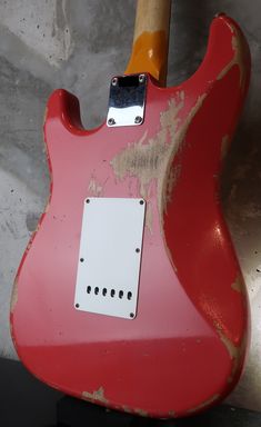 a red electric guitar sitting on top of a table