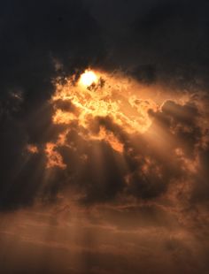 the sun is shining through some clouds in the sky, with only one light visible