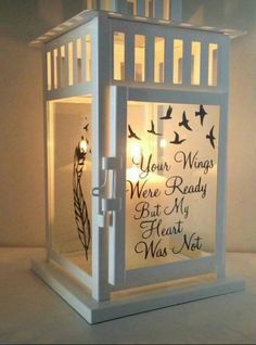 a lit candle holder with a poem written on it and birds flying over the top