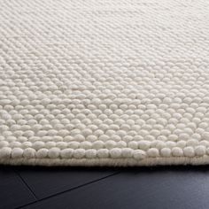 a white rug on top of a wooden floor