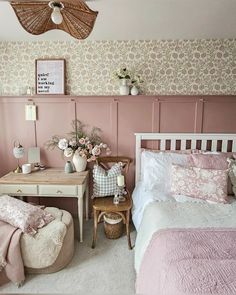 a bedroom with pink walls and white furniture