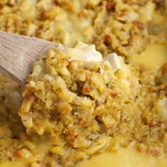 a wooden spoon mixing food into a casserole dish