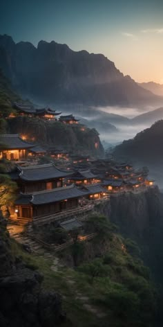 the mountains are covered in fog and lit up with lights on them, as well as buildings